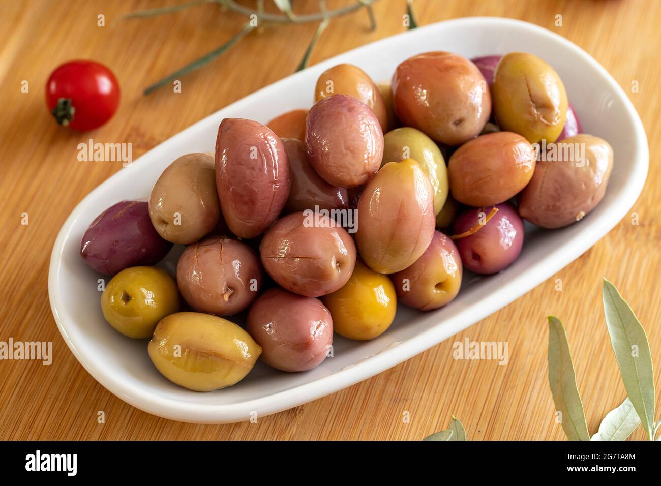 Purple kalamata olives. Tasty colored olive in the plate. Kalamata olives on wooden background Stock Photo