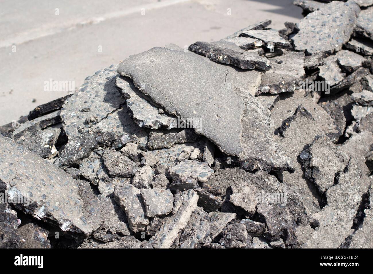 Broken asphalt. Pieces of an asphalt road. Broken road surface texture