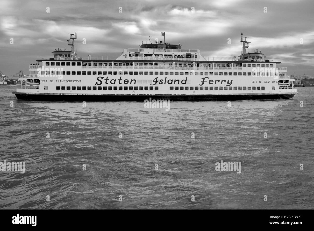 The Staten Island Ferry as it leaves its dock in Lower Manhattan, New York City.  Strong profile angle of the ship in the East River. Stock Photo