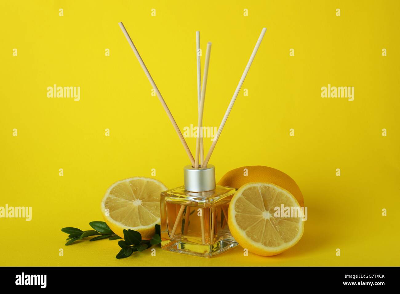 Diffuser, lemons and leaves on yellow background Stock Photo