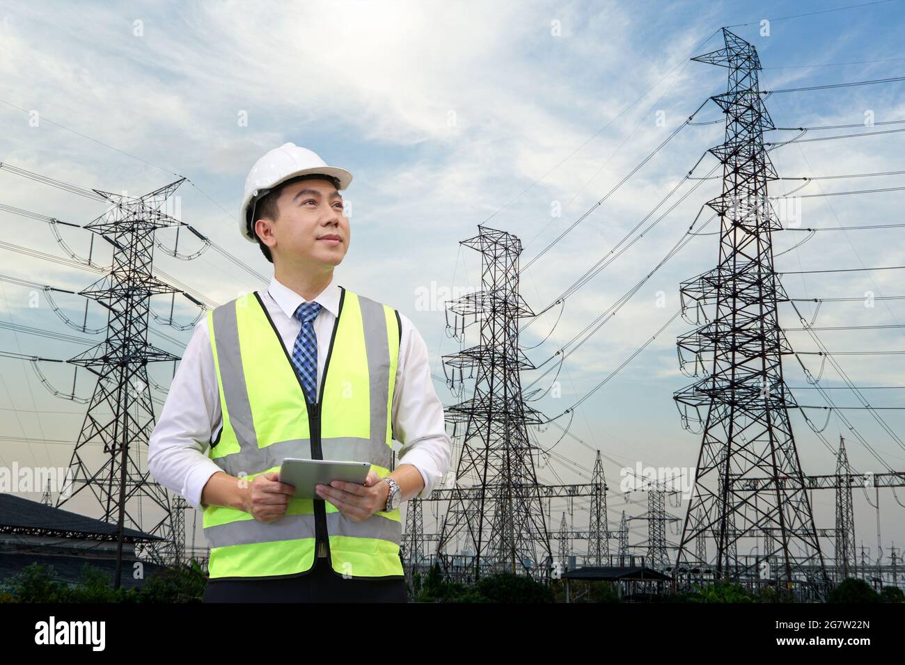 inspection engineer holding tablet computer against high electric power ...