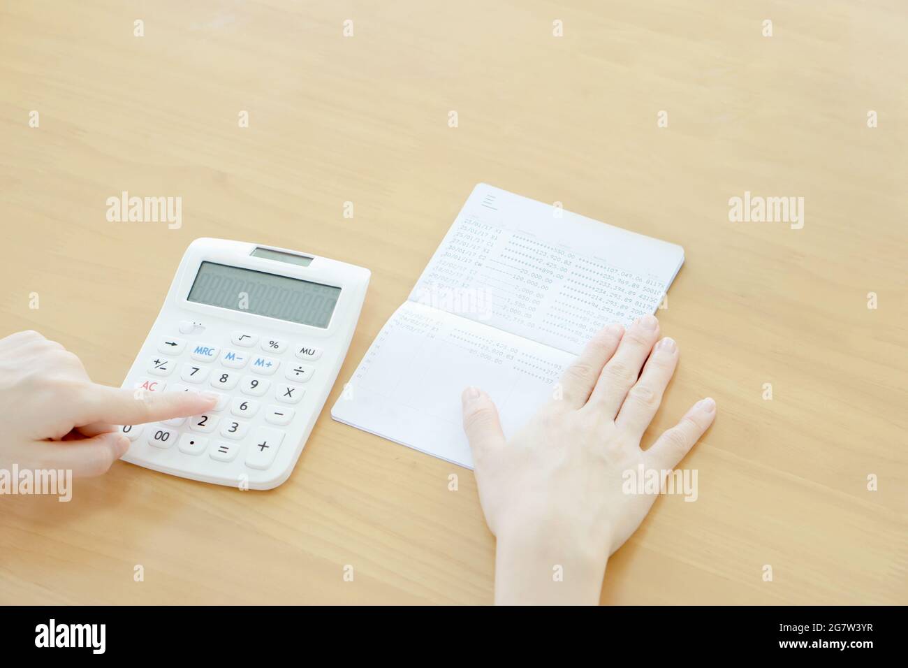 Businesswoman use calculator beside passbook Stock Photo
