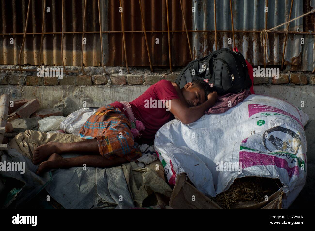 A poor hungry man is sleeping on sack. Stock Photo