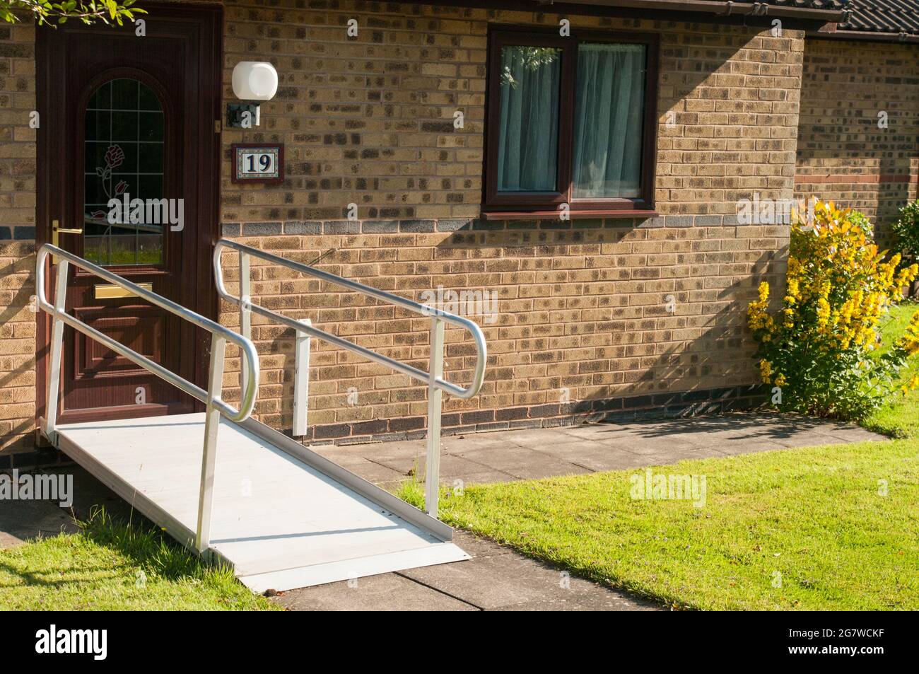 Ramp at door to enable access to wheelchairs and pavement scooters Stock Photo