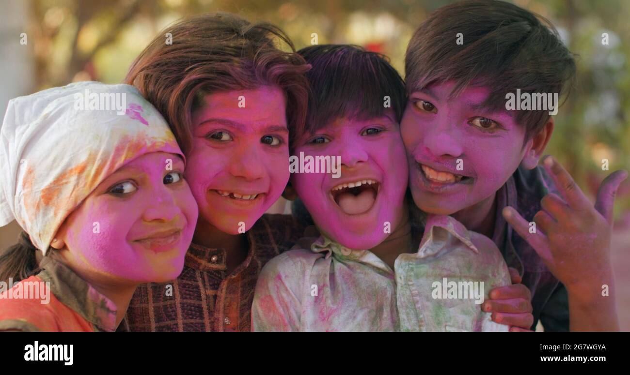 Closeup shot of South Asian children with painted pink faces during the Indian Holi Festival Stock Photo