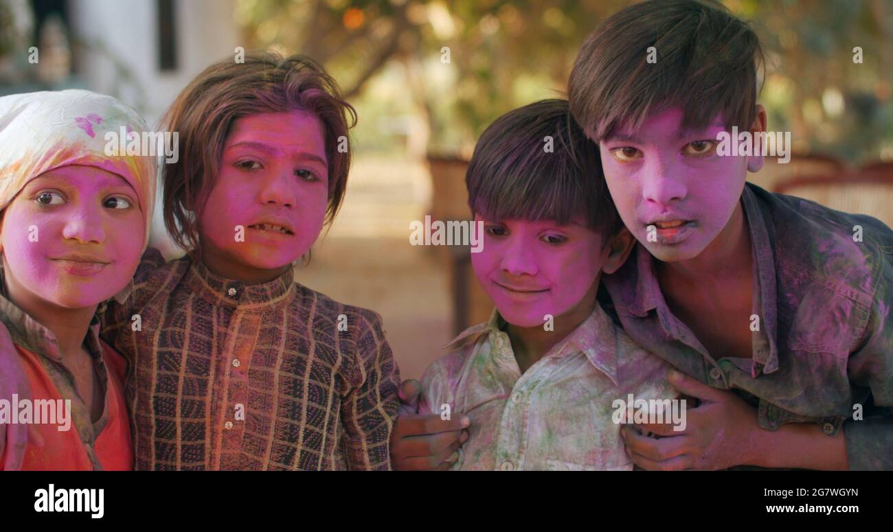 Closeup shot of South Asian children with painted pink faces during the Indian Holi Festival Stock Photo