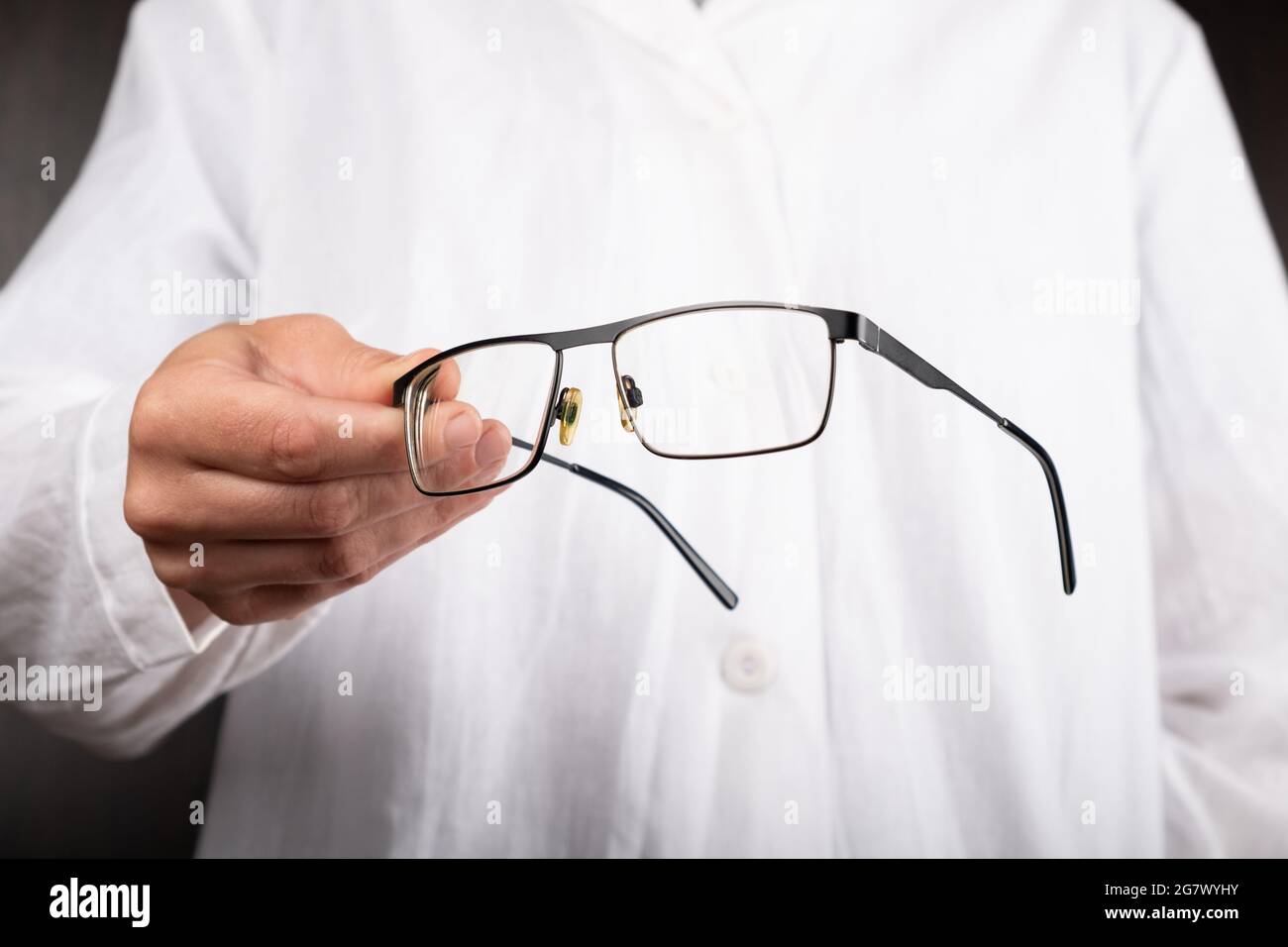 optician doctor  gives glasses to a patient to improve vision. Stock Photo