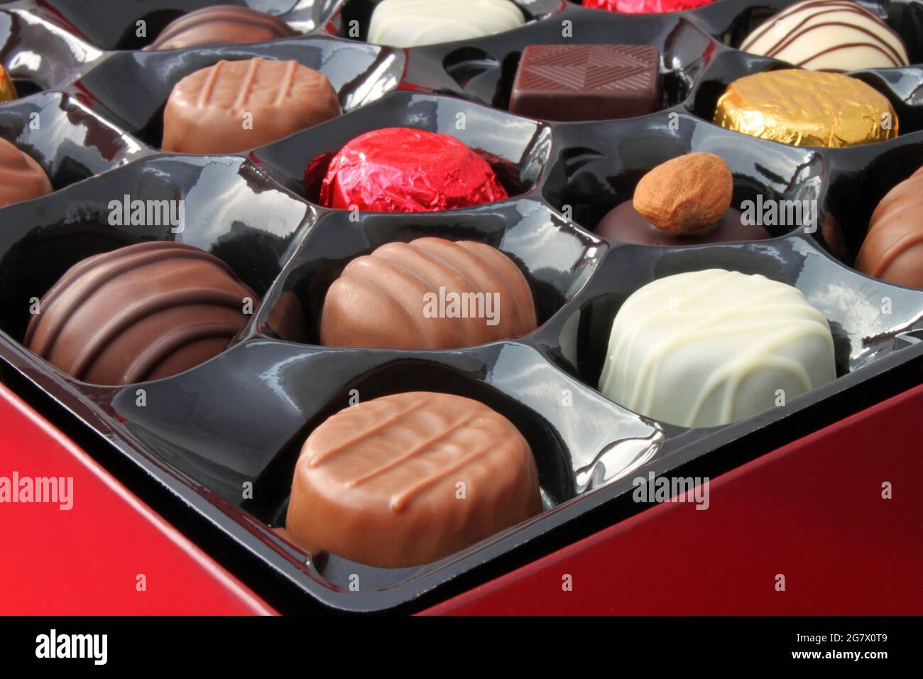 A closeup of a red box full of tempting chocolates. Stock Photo