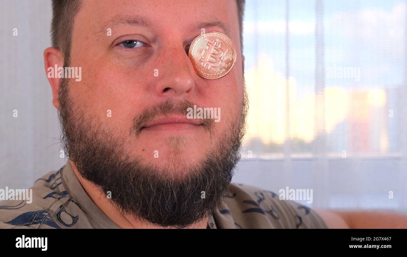 man holds bitcoins. Male with bitcoin in eye. Bitcoin is a cryptocurrency  invented in 2008 by an unknown person or group of people using the name  Stock Photo - Alamy