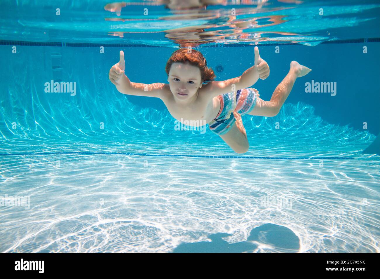 Underwater kid swim under water. Child boy swimming and diving
