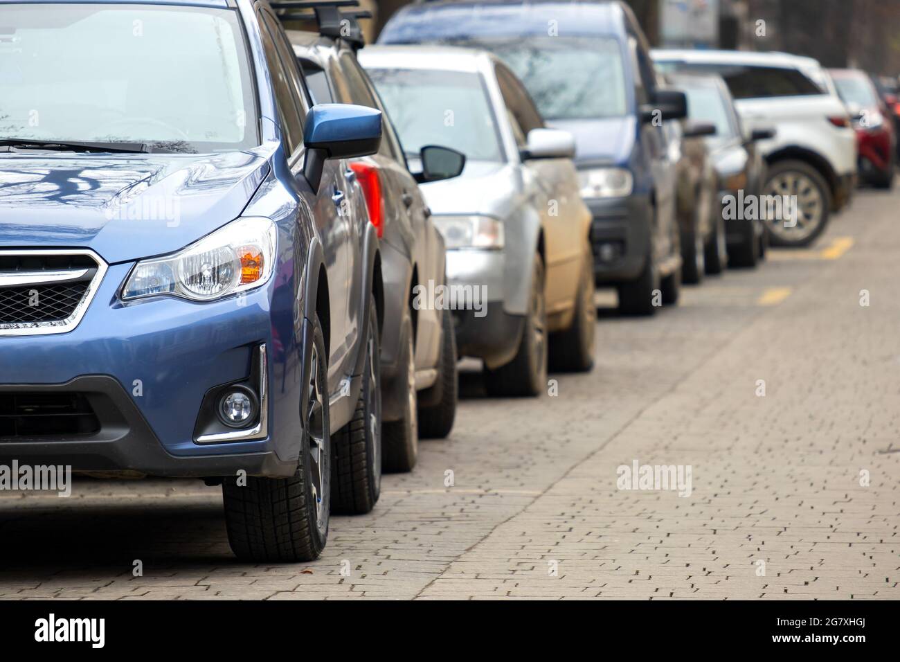 Cars parked in a row on a city street side Stock Photo - Alamy