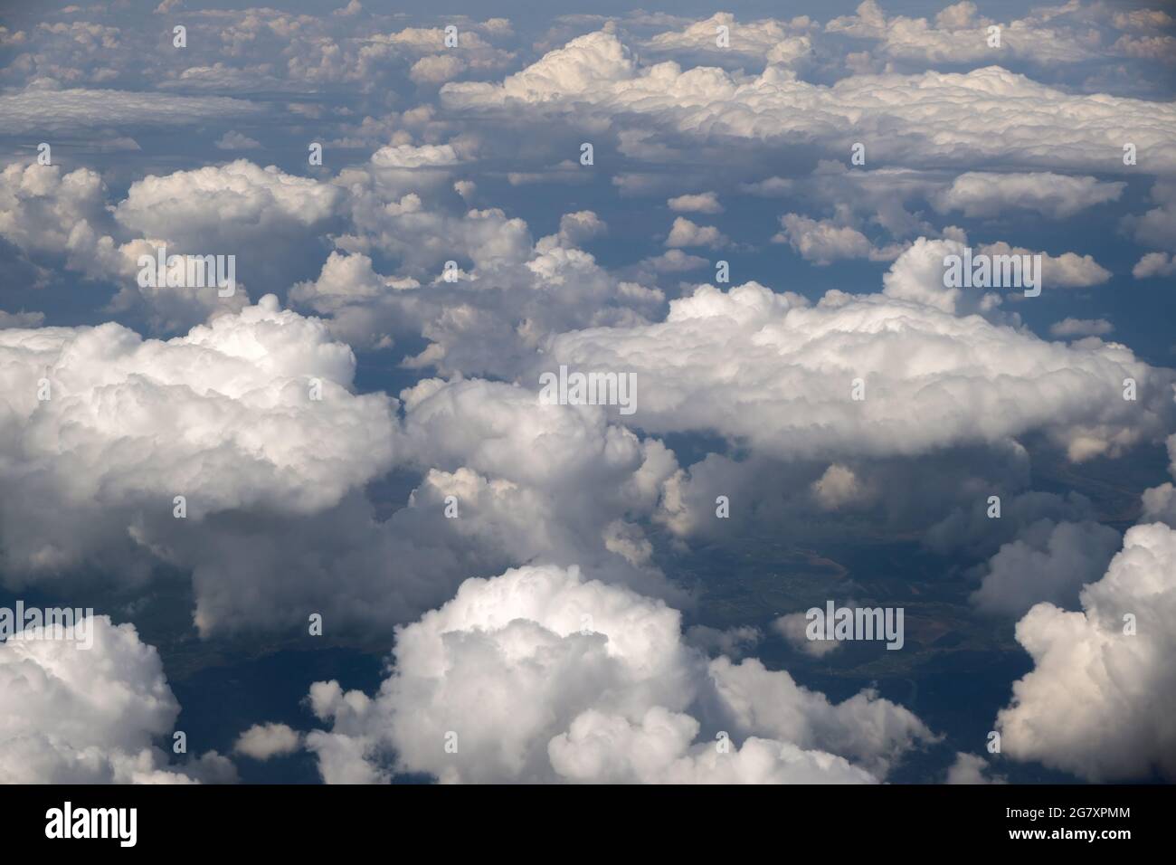 Aerial view from airplane window of white puffy clouds on bright sunny ...