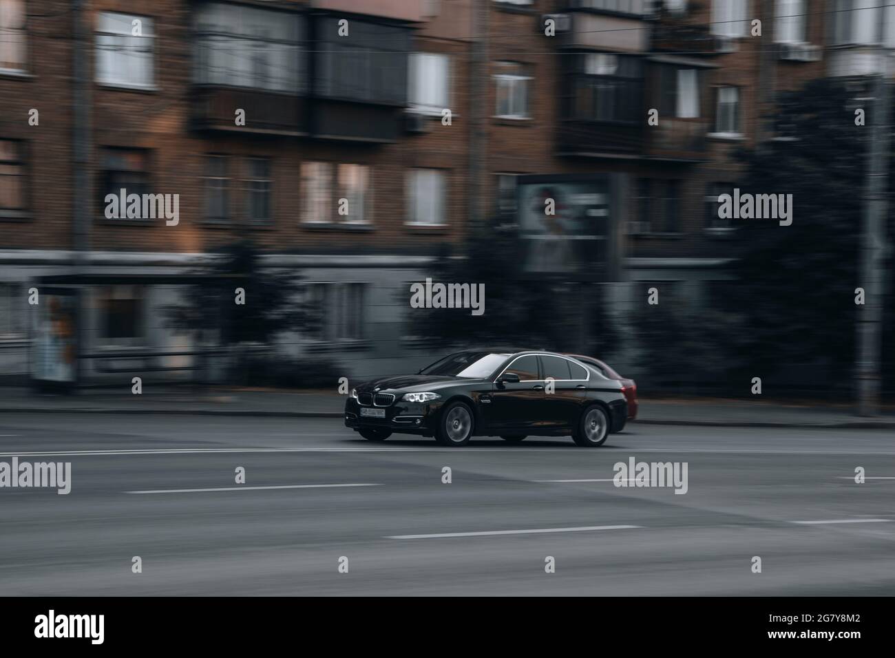 Ukraine, Kyiv - 16 July 2021: Black BMW 5 Series car moving on the street. Editorial Stock Photo