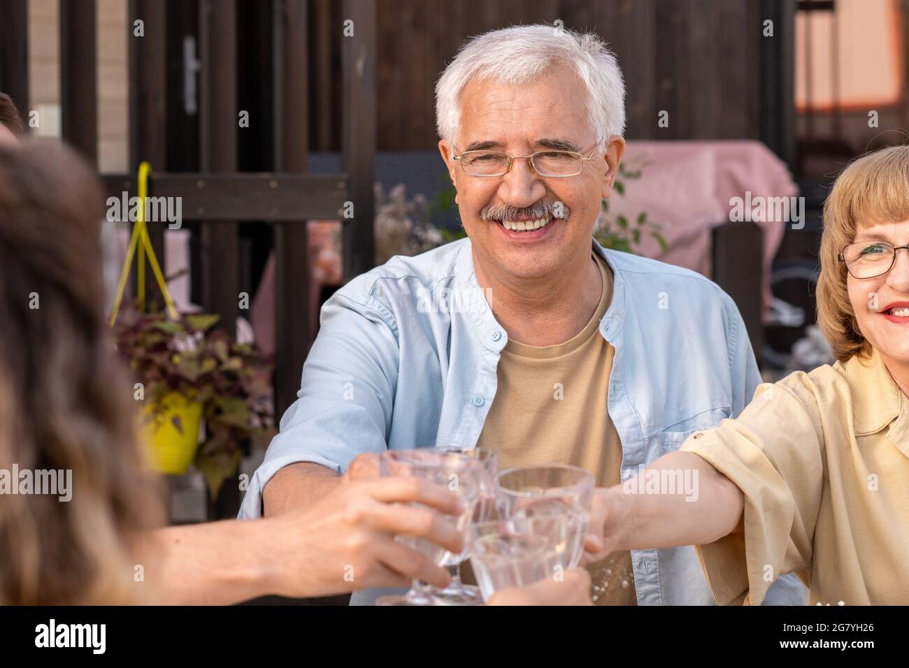 Happy senior couple toasting at birthday dinner party with their adult children Stock Photo