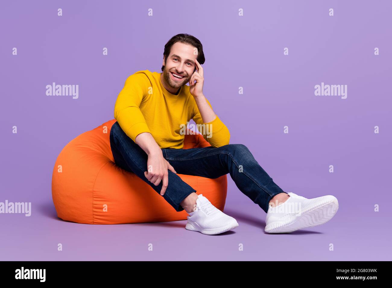 Full length body size photo guy sitting in beanbag smiling in casual
