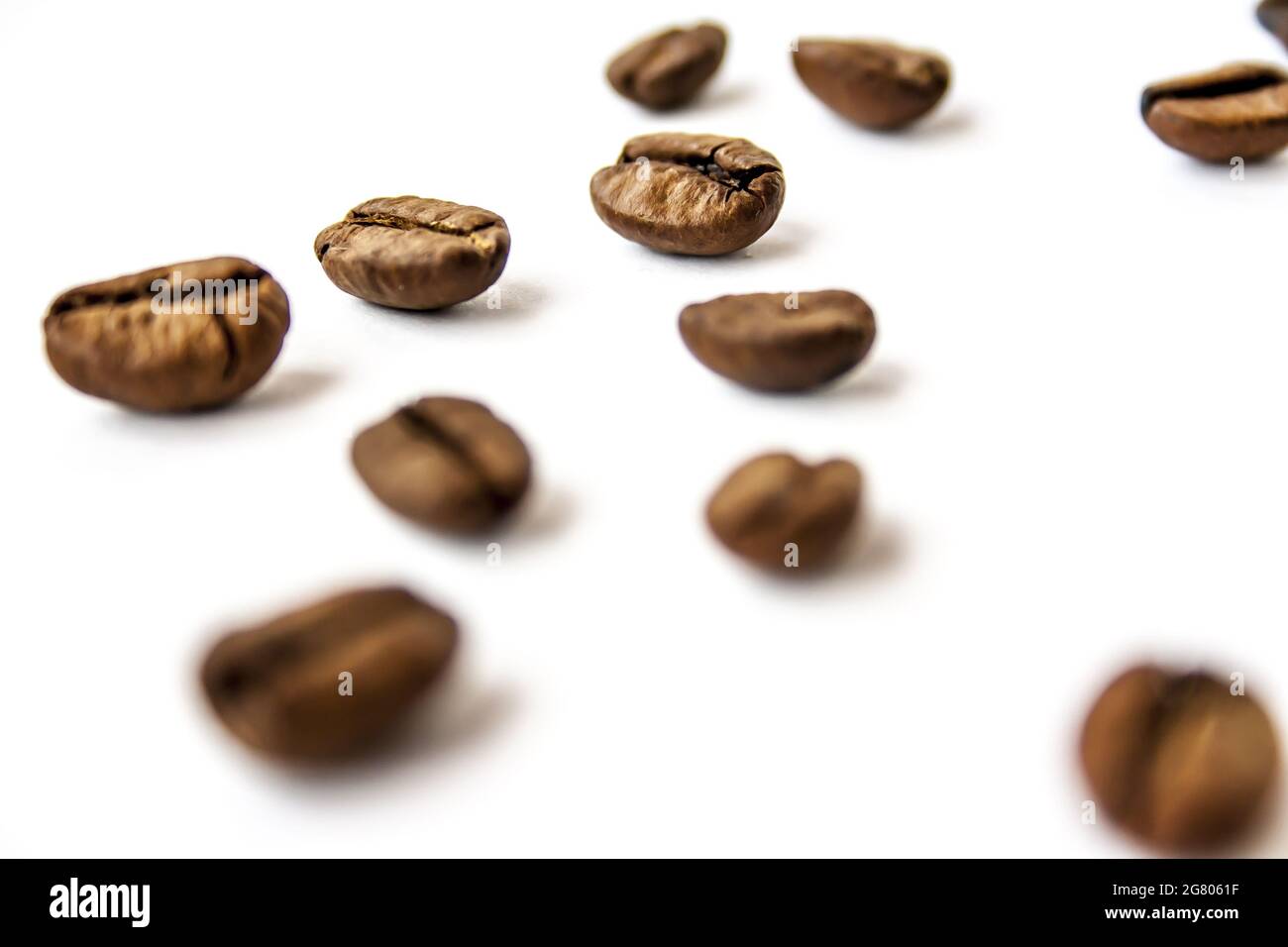 Heap of roasted coffee beans on a white surface Stock Photo - Alamy