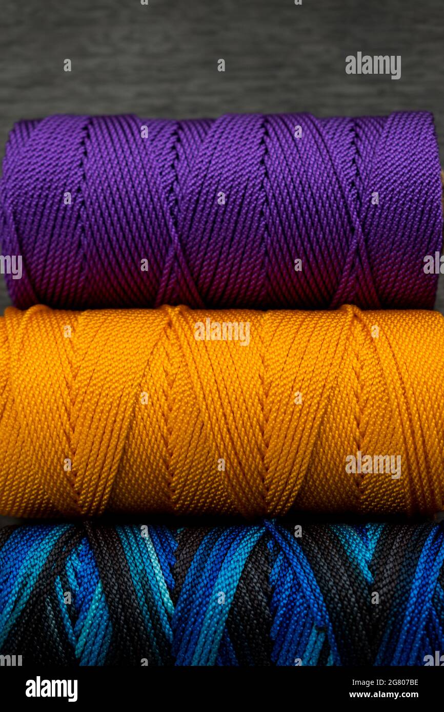 Close up of some different colorful rolls of thread on a black wooden ...