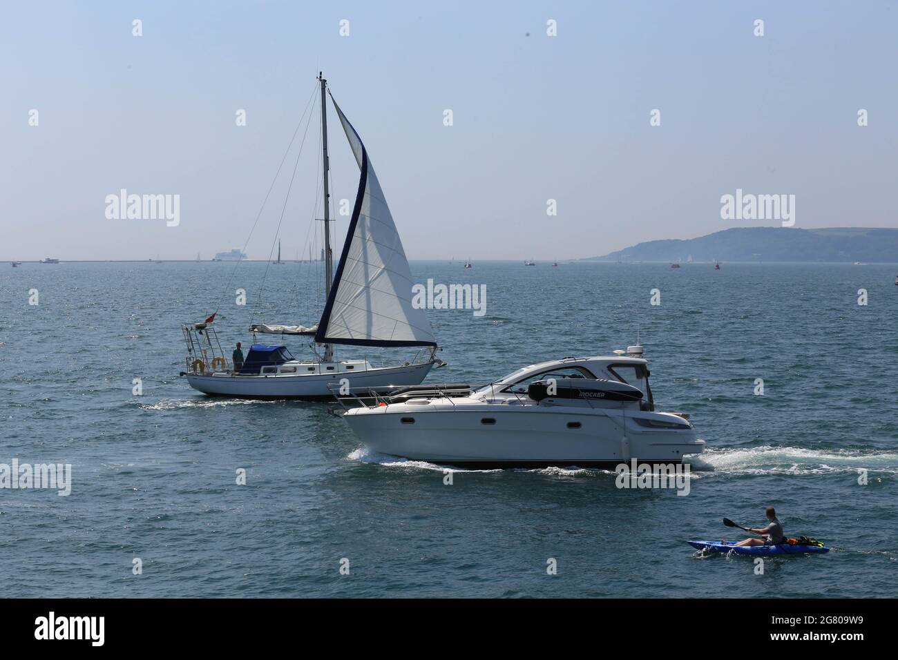 SAILING AND YACHT  AND KAYAKER PASSING CLOSE TO EACH OTHER Stock Photo