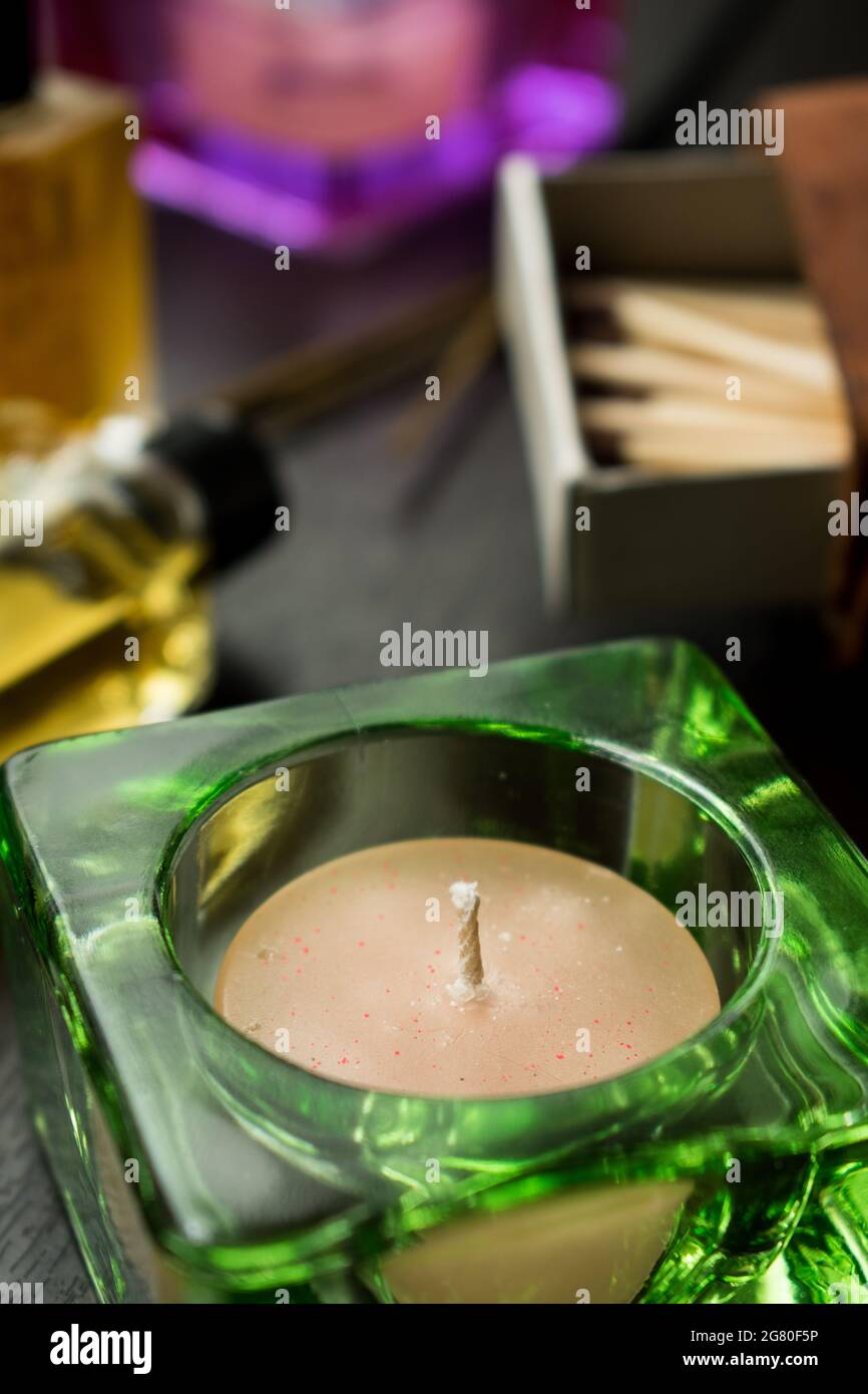 Some wooden matches in a matches box, candles and some glass flovering bottles on a black wooden table Stock Photo