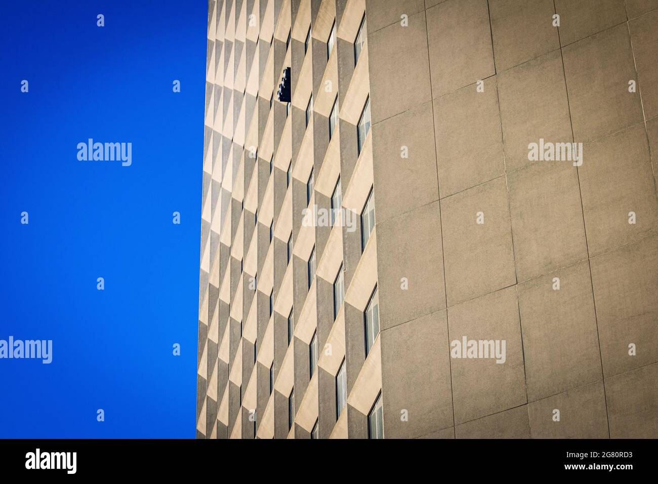 side of a tall skyscraper up against a clear blue sky Stock Photo