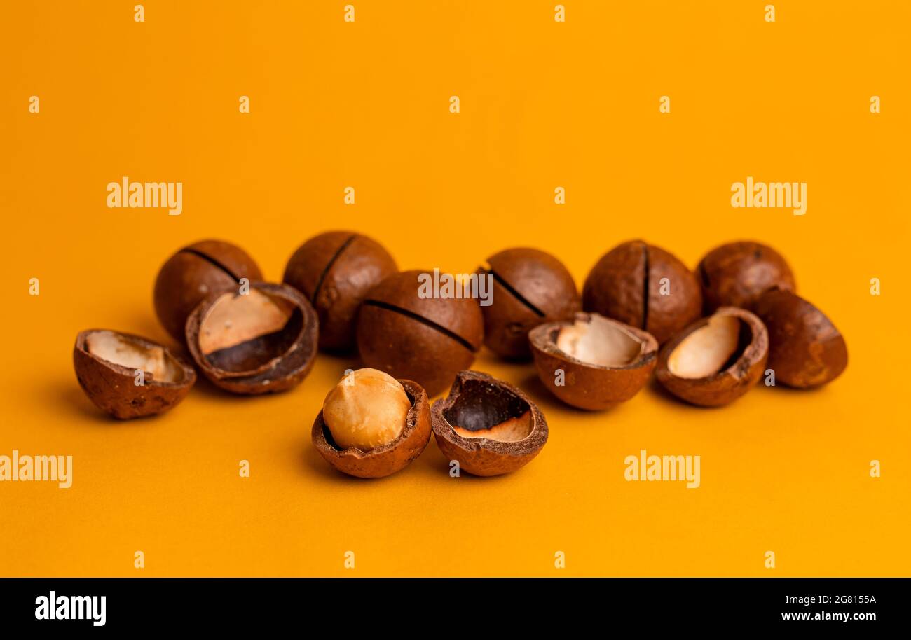 split macadamia nut close-up on an orange background. Stock Photo