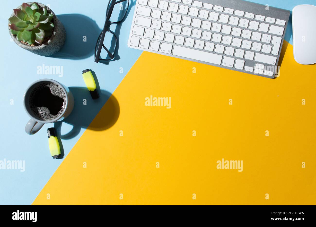 Work table with a blue and yellow background Stock Photo - Alamy