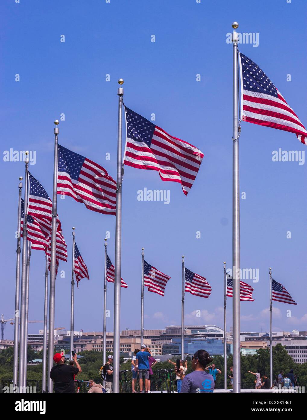 American Flags Wave in the Wind Below the Washington Monument Stock Photo