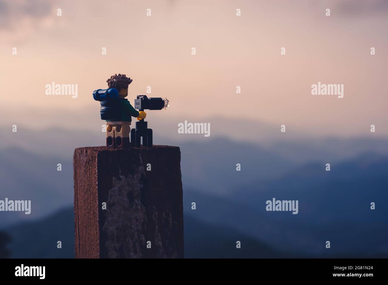 Silhouette of nature photographer taking photos at sunset in the foggy mountains. Illustrative editorial. July 15, 2021 Stock Photo