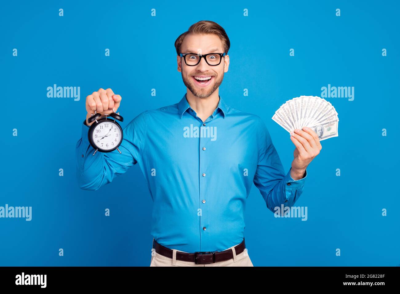 Photo of young man happy positive smile hold clock timer money wealthy ...