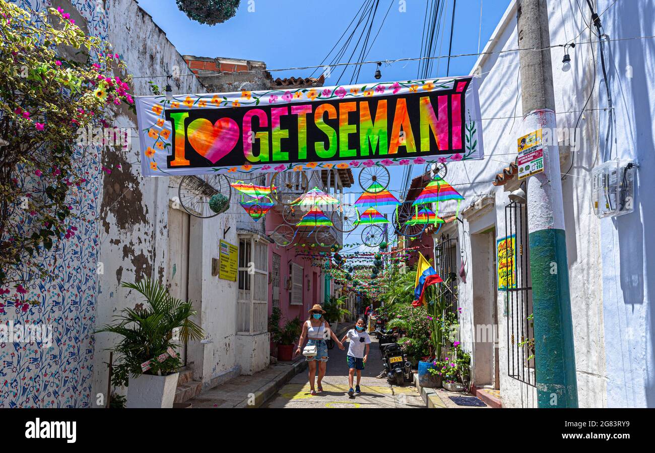 Narrow street decorated with colourful banner, Callejón Ancho, Barrio Getsemani, Cartagena de Indias, Colombia. Stock Photo