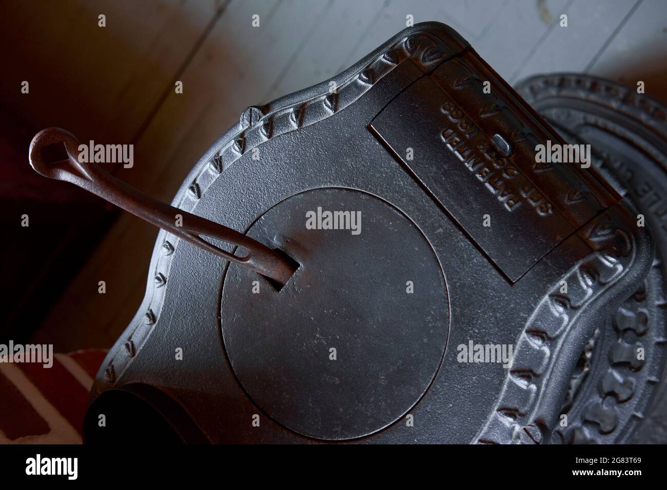 A cast iron coal stove is seen viewed from above in a rustic setting. Stock Photo