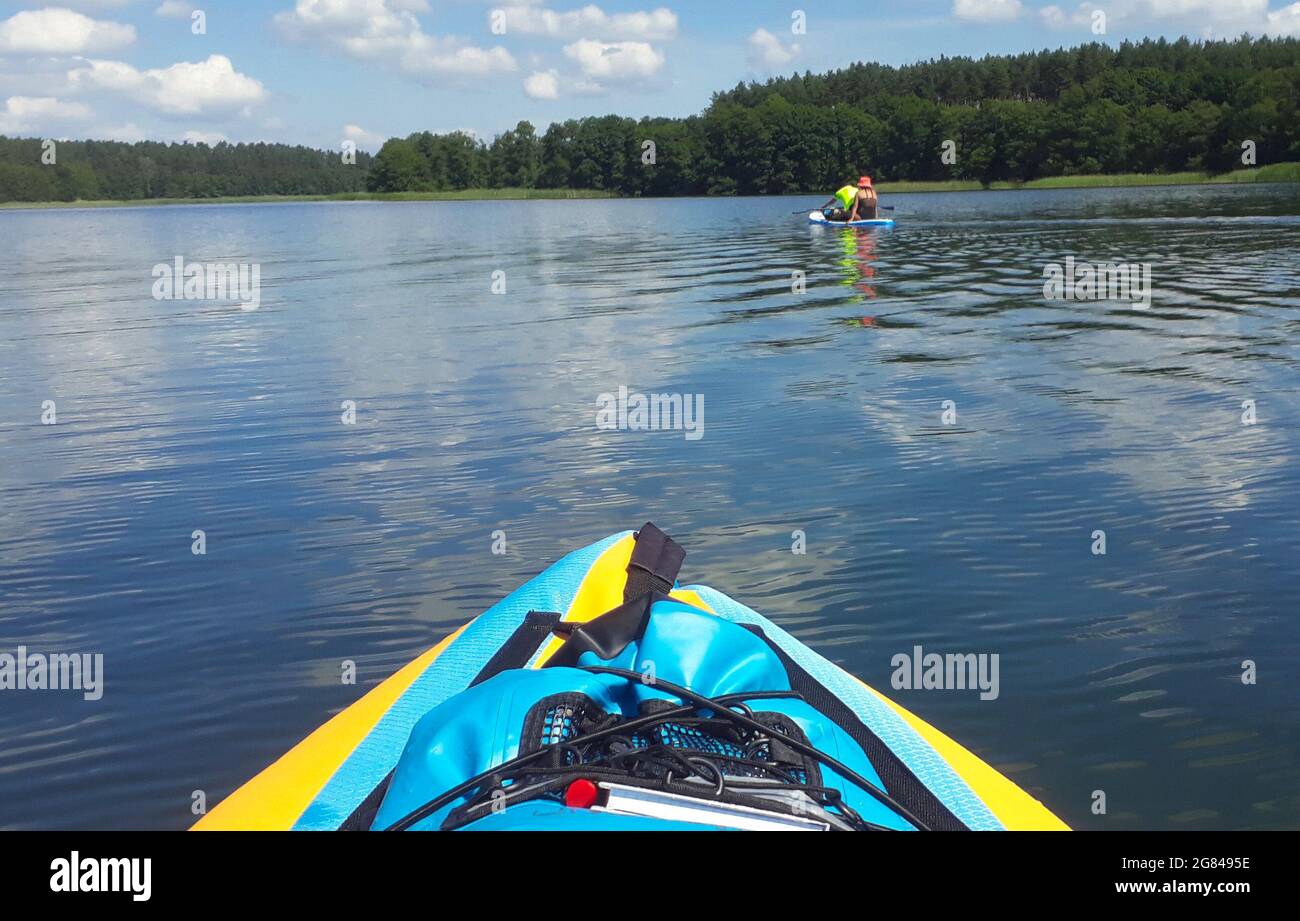 Schweinrich, Germany. 04th July, 2021. On the Dranser See lake on the edge  of the Stechlin-Ruppiner Land nature park (Ostprignitz-Ruppin), water  sports enthusiasts use inflatable kayaks and stand-up paddle boards. (to  dpa: "