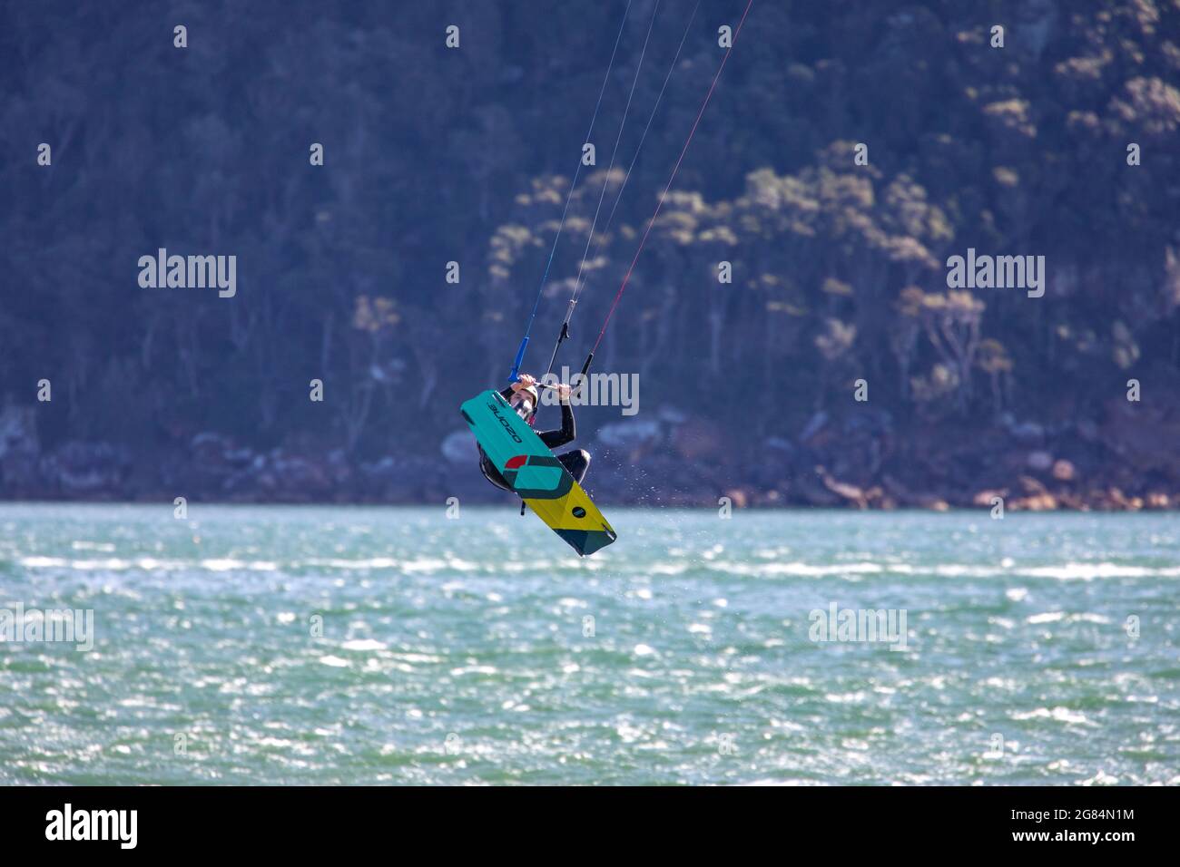 Kite surfer up in the air whilst kite boarding on Pittwater during a windy winters day,Sydney northern beaches,Australia Stock Photo