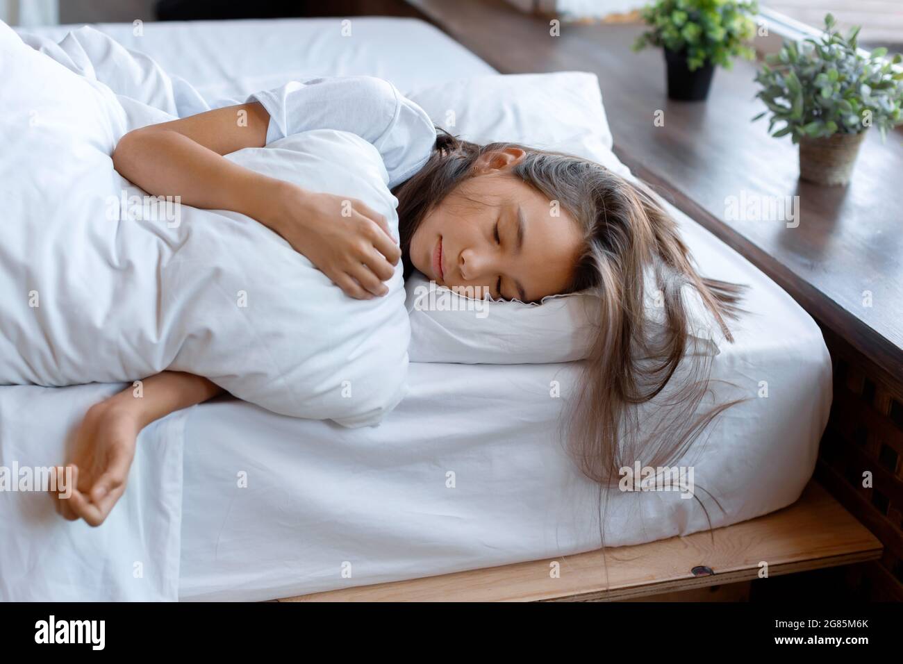 Photo of a 10yearold girl sleeping under a blanket before awakening