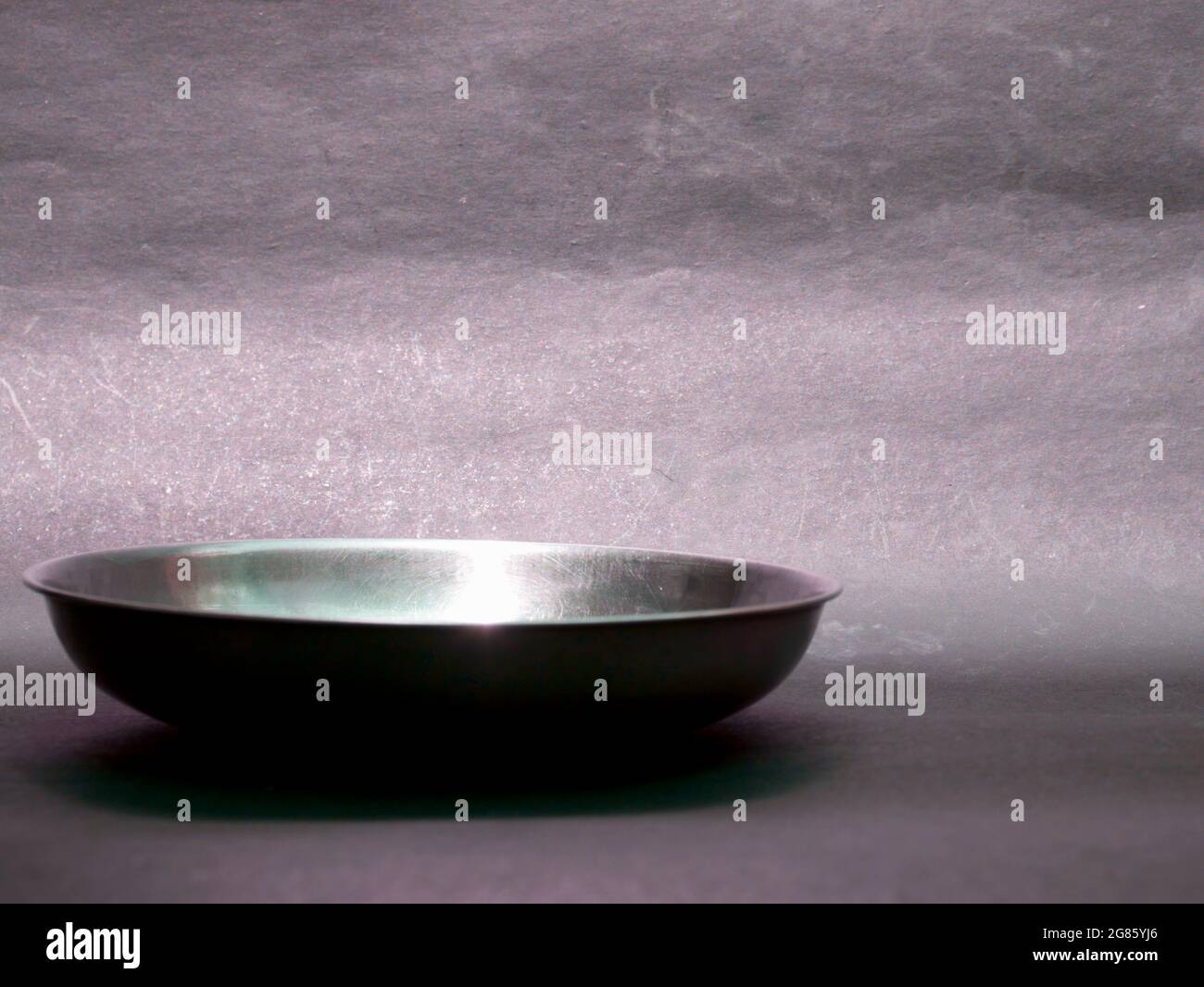 Stainless steel indian style food plate displayed on gray backdrop