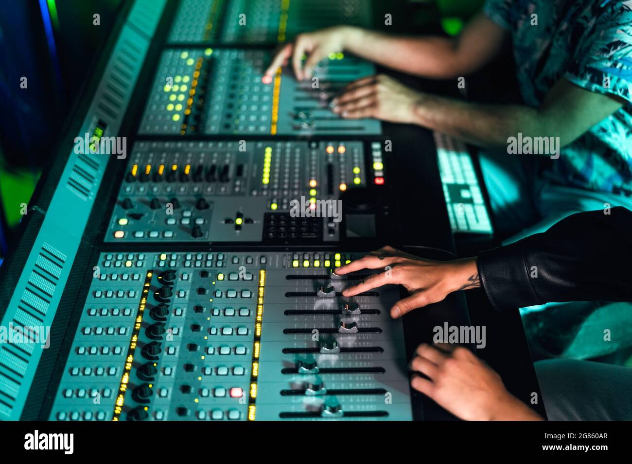Close up audio engineer hands working with panel mixer control in music recording studio Stock Photo