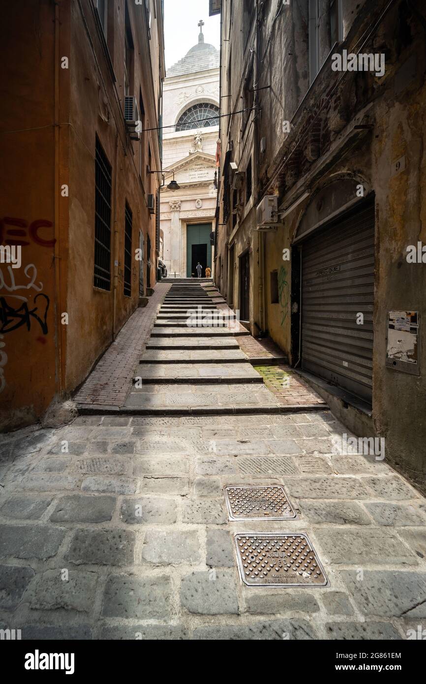 Genoa, Italy, historic centre; a typical caruggio narrow alley with the Basilica di San Siro church in the background Stock Photo