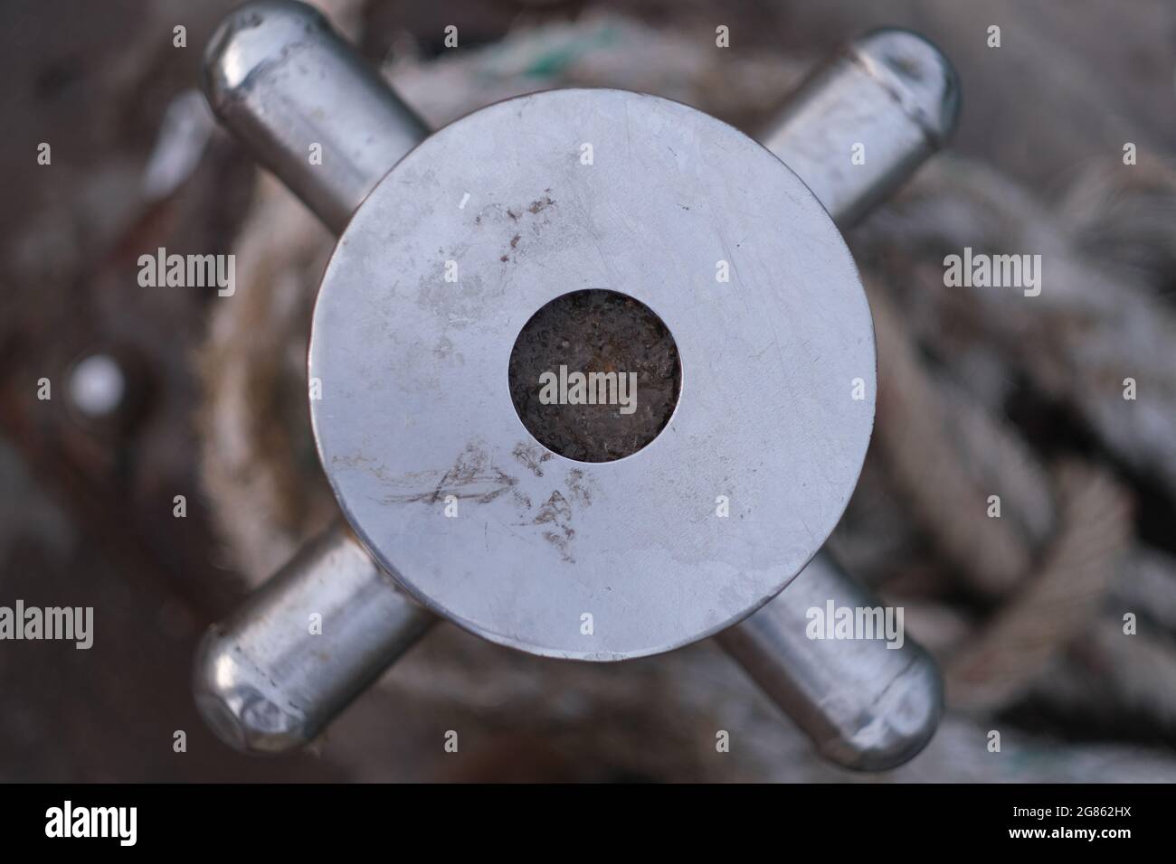 A top of stainless steel mooring rod at sea wharf, with bight of rope on it Stock Photo