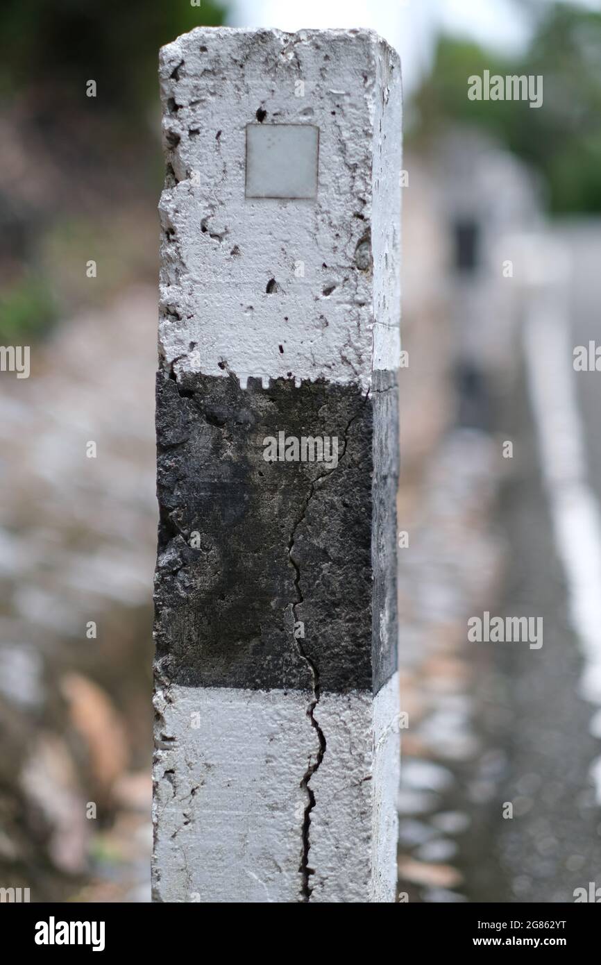 An unnamed mile marker aside of a small rural road Stock Photo