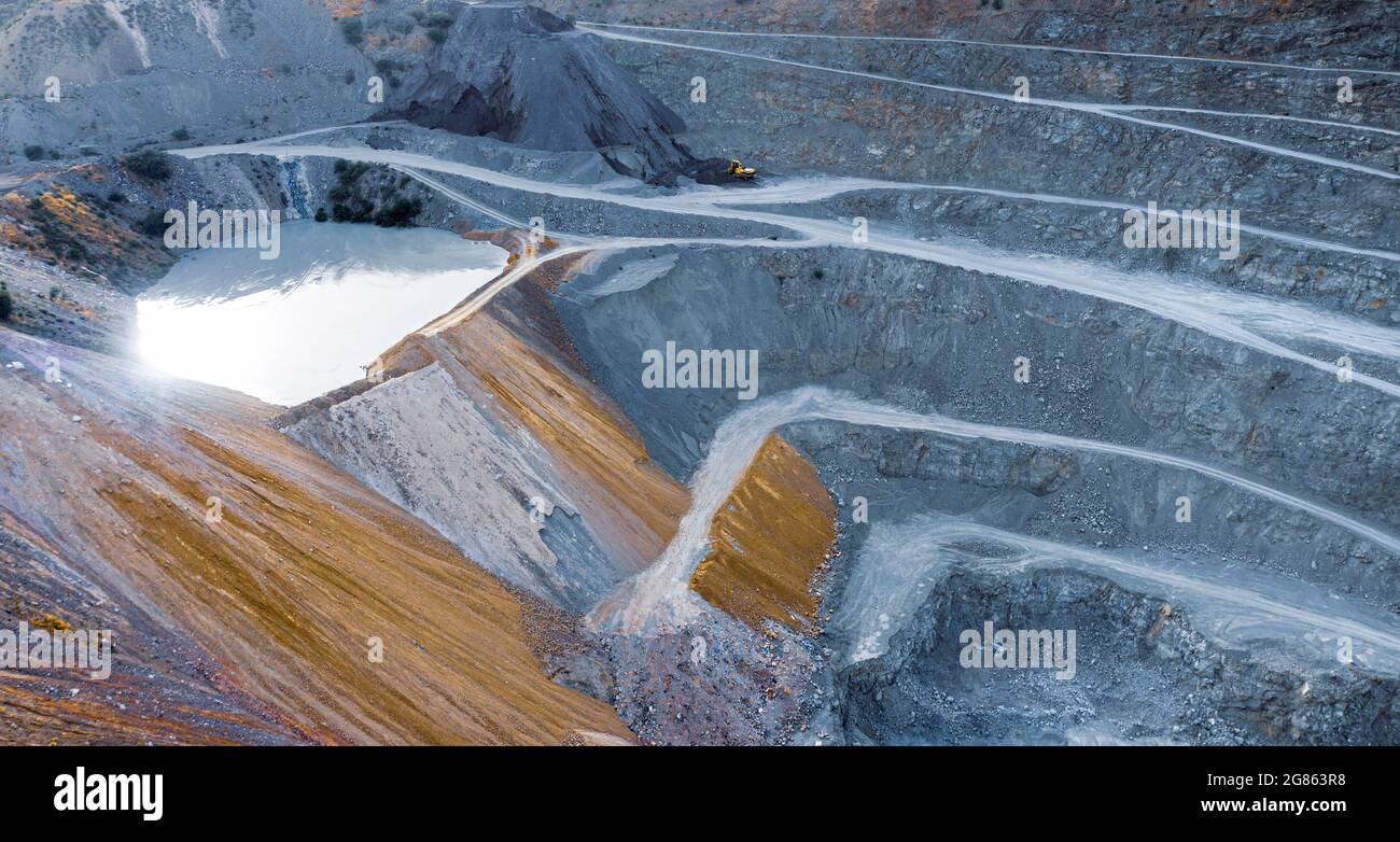 Aerial view on gravel quarry with terraces, pool of water and stone crusher machine Stock Photo