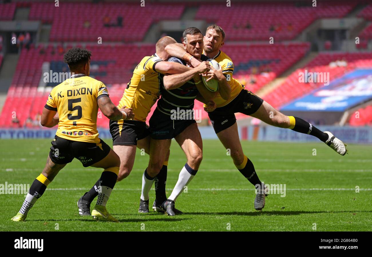 Featherstone Rovers' Craig Hall (centre) tackled by York City Knights' Danny Washbrook (2nd left) and Danny Kirmond (right) during the 1895 Cup final match at Wembley Stadium, London. Picture date: Saturday July 17, 2021. Stock Photo