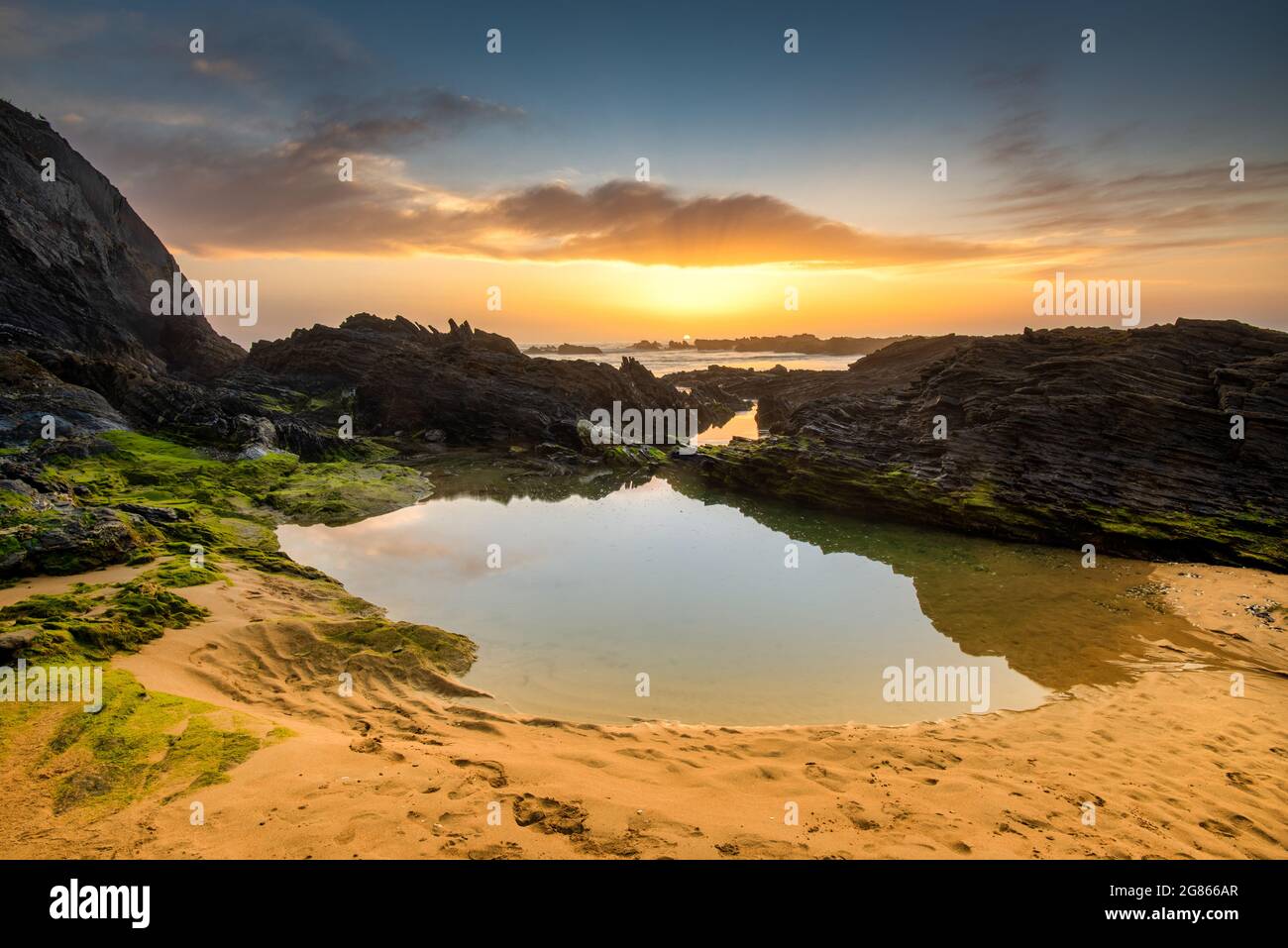 Landscape with sunset over Portuguese West coast and rocky Praia do Vale dos Homens Stock Photo