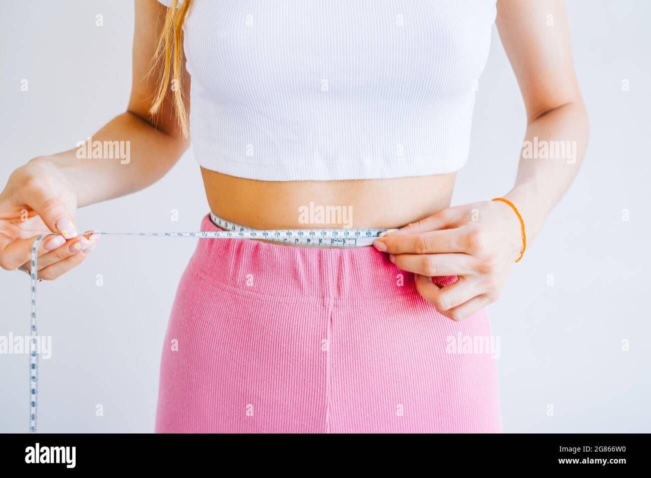 https://c8.alamy.com/comp/2G866W0/slim-woman-measuring-her-waists-size-with-tape-measure-on-white-background-successful-weight-loss-slim-fit-concept-2G866W0.jpg