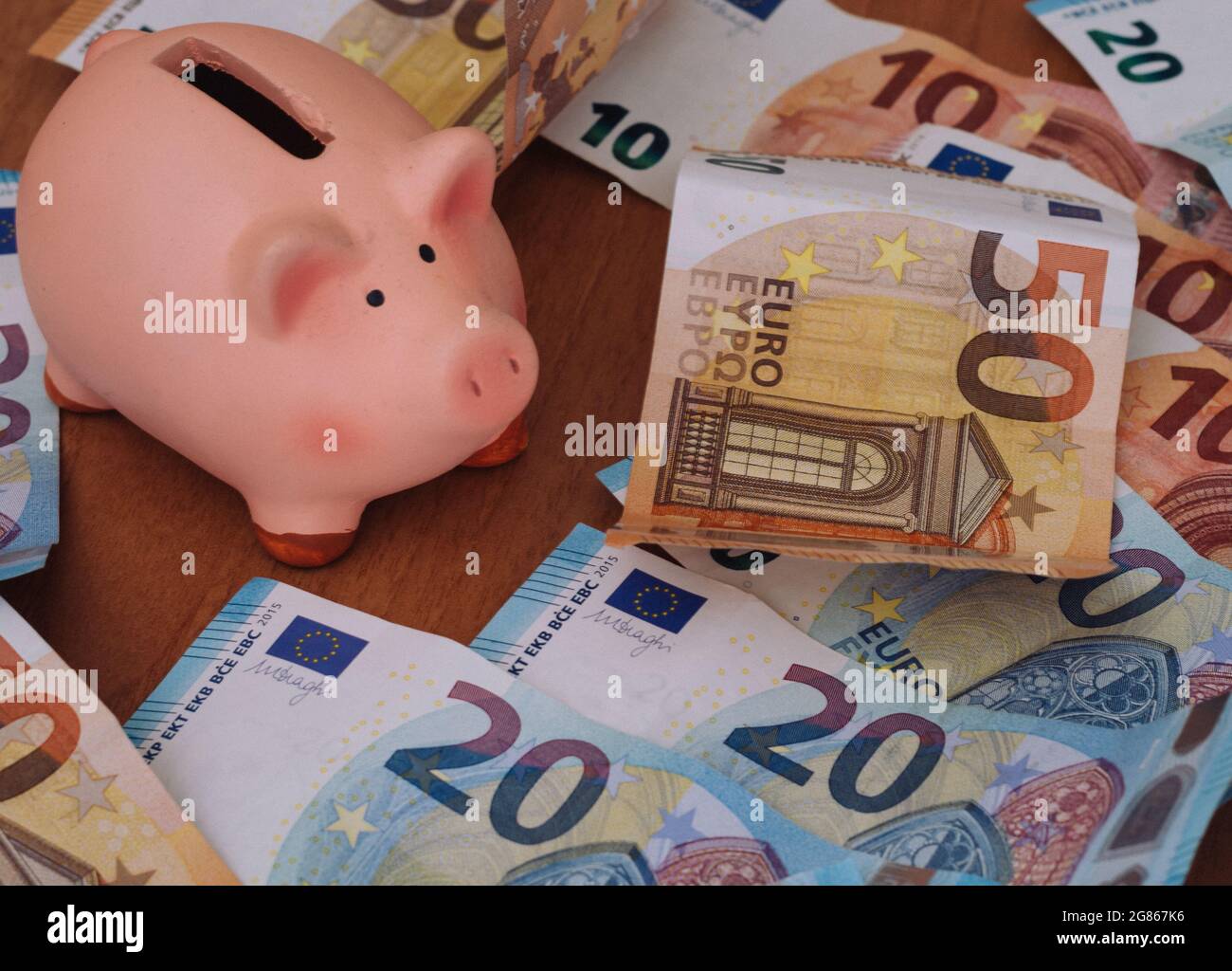 Piggy bank surrounded by European 50, 20 and 10 euro banknotes Stock Photo