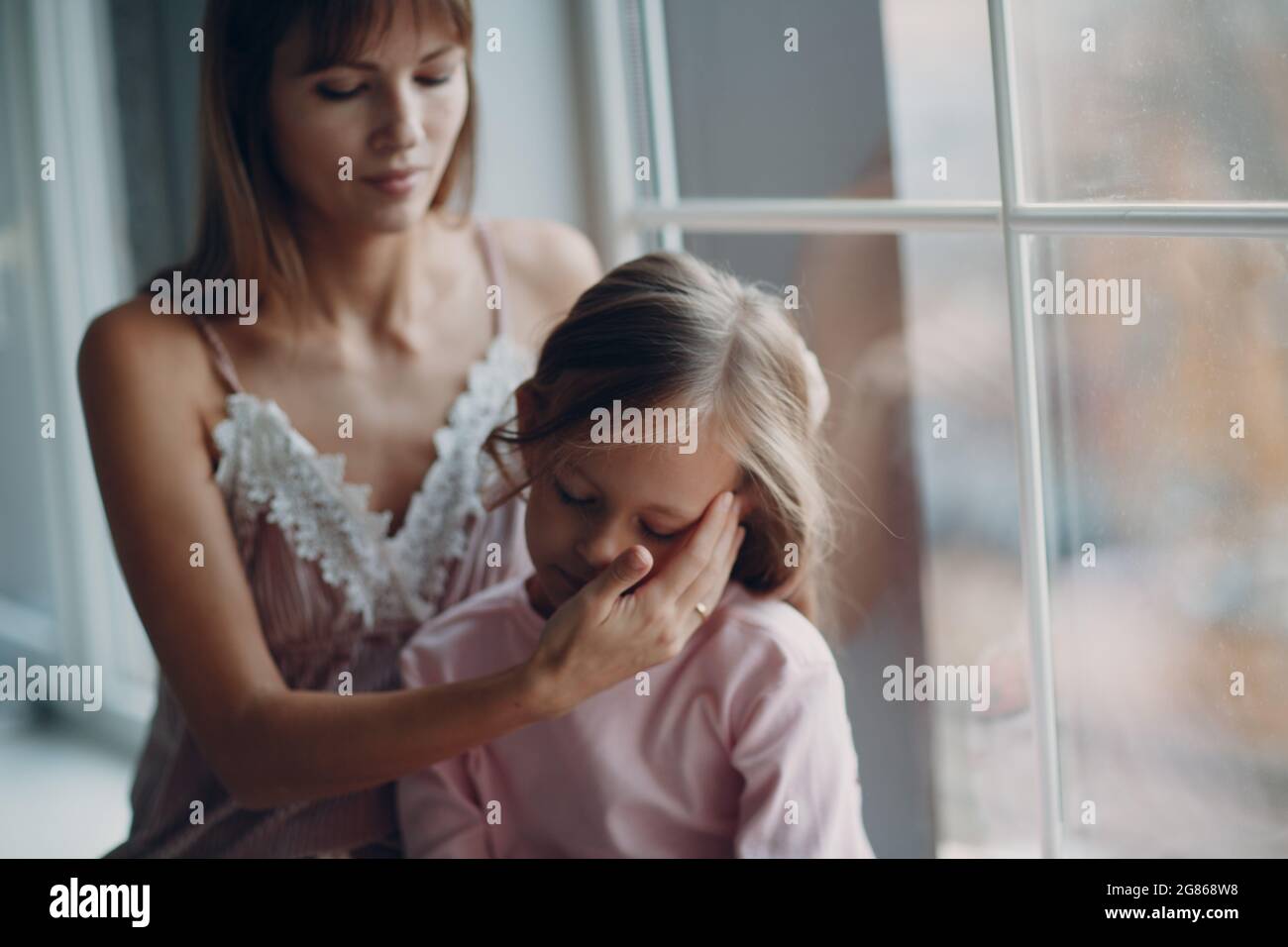 Mother and little daughter child girl at home. Single parenting and motherhood. Stock Photo