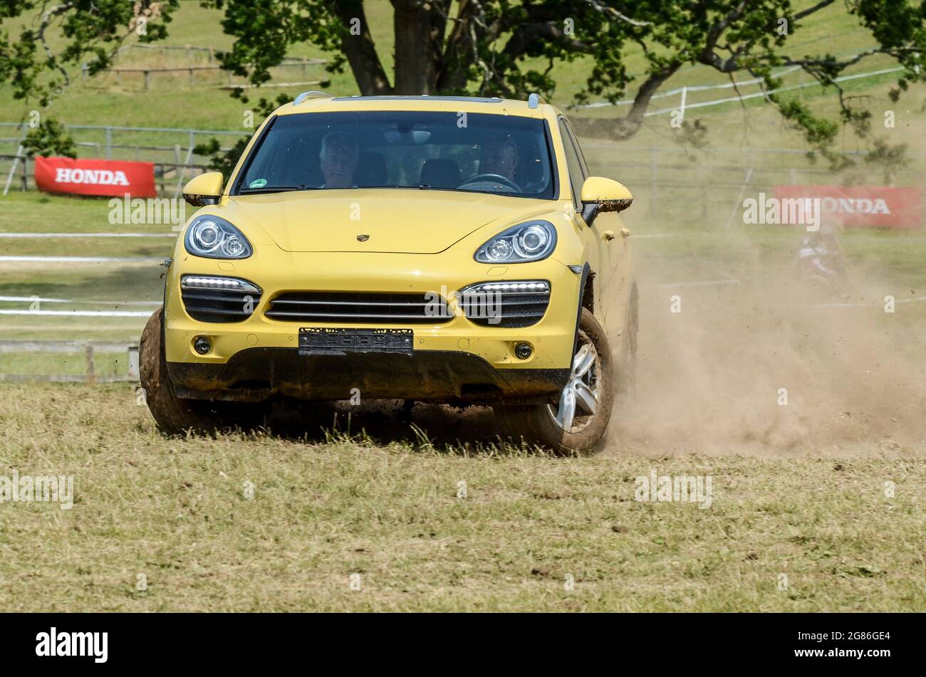 Porsche Cayenne SUV car giving rally experiences on a rally stage at the Goodwood Festival of Speed 2013. Up market four wheel drive getting dirty Stock Photo