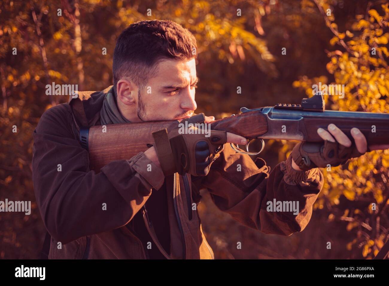 Hunter with shotgun gun on hunt. Autumn hunting season. Autunm hunting