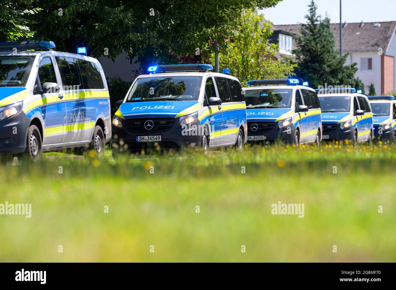 Germany. 17th July, 2021. 17 July 2021, Schleswig-Holstein, Henstedt-Ulzburg: Police squad cars drive behind the demonstration with flashing blue lights. Nine months after an incident at an anti-AfD demonstration, several hundred people from the left-wing scene have again demonstrated in Henstedt-Ulzburg (Segeberg district). On 17.10.2020, an AfD sympathizer had hit and injured participants of a rally against an AfD event with his car. Photo: Jonas Walzberg/dpa Credit: dpa picture alliance/Alamy Live News Stock Photo