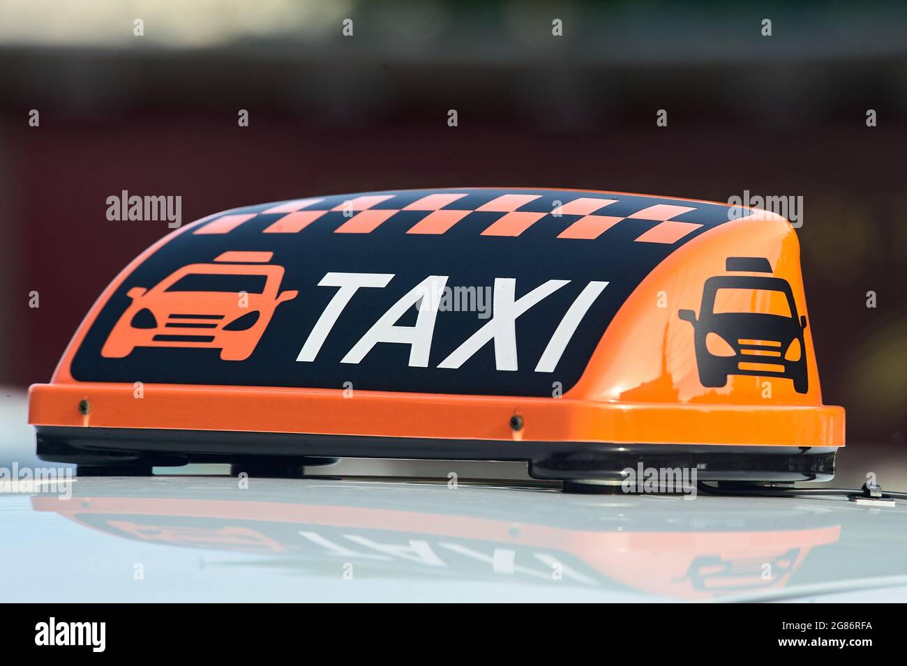an orange taxi sign stands on the roof of the car Stock Photo
