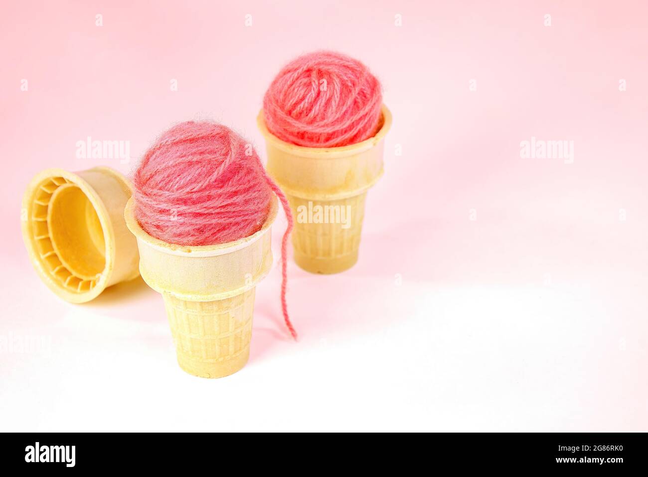 Pink yarn balls in ice cream cones isolated on pink background Stock Photo
